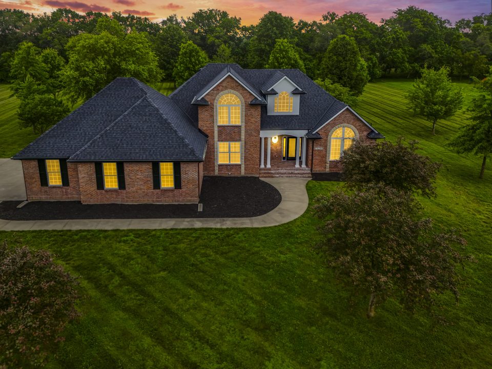 An aerial photo of a brick home at dusk