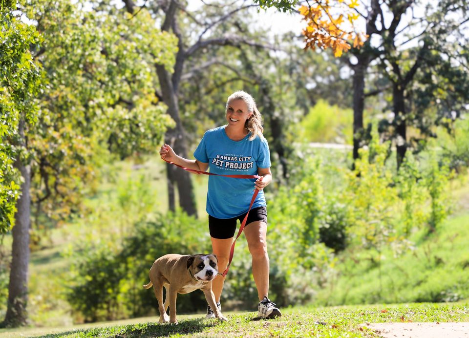 An environmental portrait of a woman walking her dog on a trail
